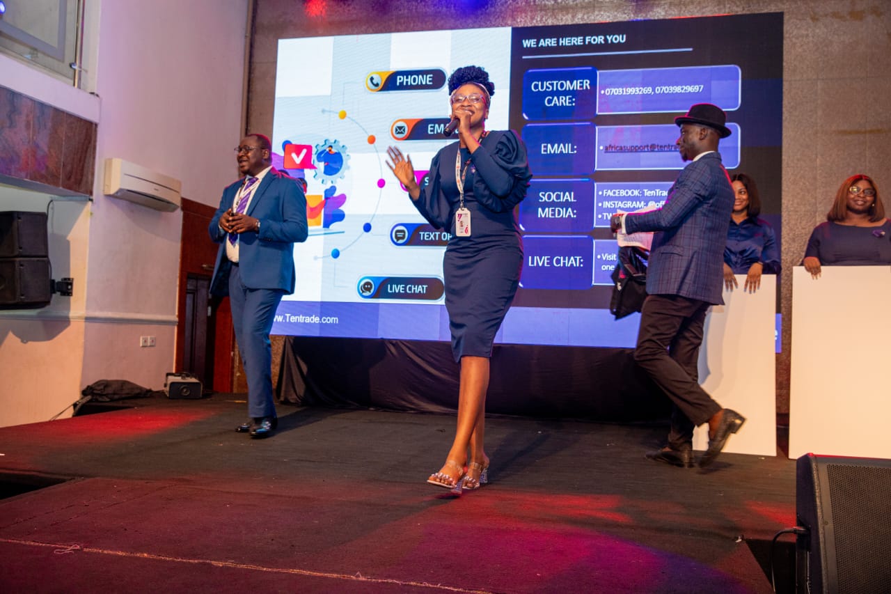 Blessing-Jehova Ubong presenting a customer support slide on stage with colleagues